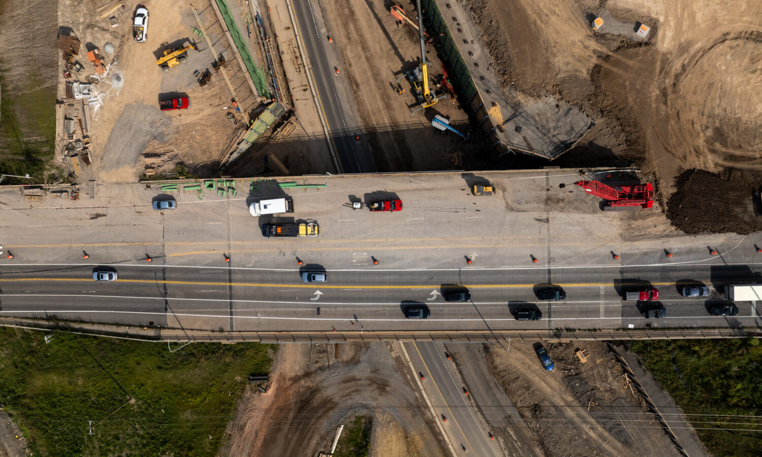 Aerial view: vehicles and equipment on partially built highway.
