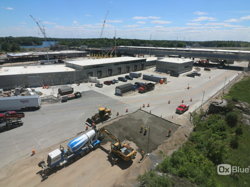 Aerial view: Construction site near road and large industrial buildings