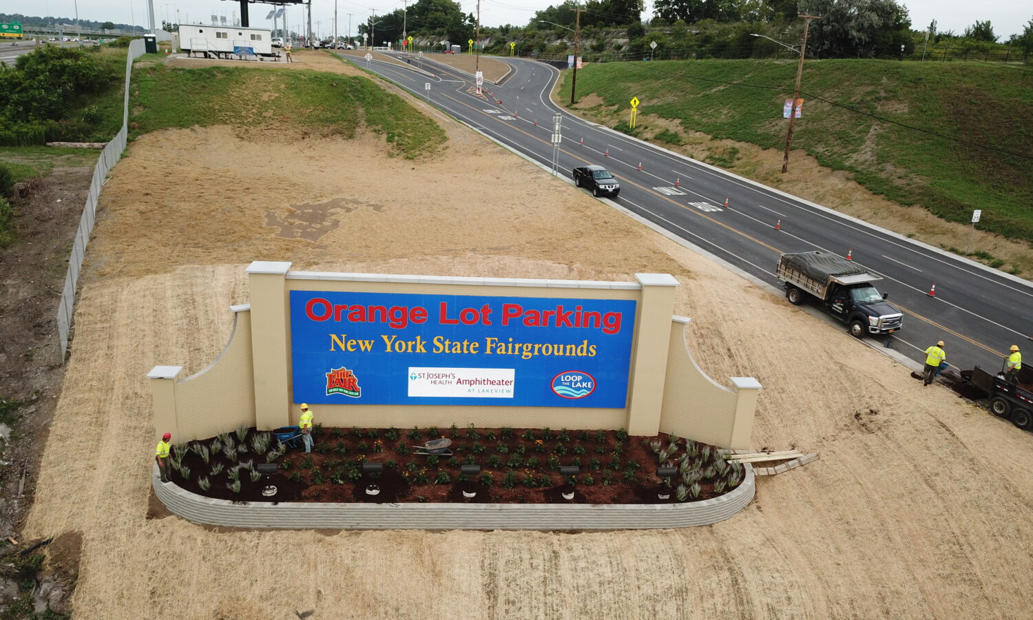 Aerial view: Sign for Orange Lot Parking of New York State Fairgrounds on the side of the road.